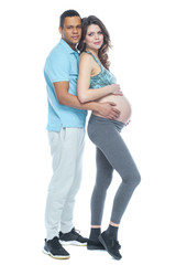Handsome black man and his beautiful pregnant wife are hugging and smiling while. Isolated white background.