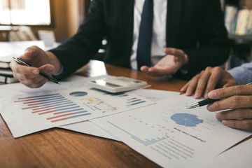 Two business partnership coworkers analysis strategy with discussing a financial planning graph and company budget during a budget meeting in office room.