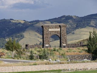 Wide shot of the stone Roosevelt Arch in Gardiner, the north entrance to Yellowstone National Park.