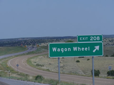 Medium close up shot of a directional sign on the highway with directions to Wagon Wheel exit in New Mexico.