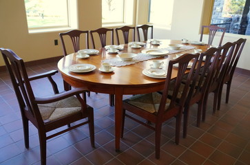 A dining table with glassware overlooking a bright window