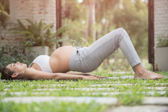 beautiful pregnant woman doing sport in park. yoga outdoors. active and sportive pregnancy, healthy motherhood concept. fitness and healthy lifestyle during pregnancy. Pregnant girl with big tummy