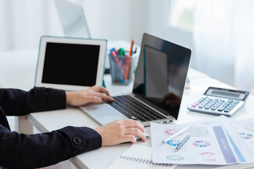 Business woman using a calculator to calculate the numbers on his desk in a office.