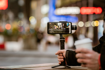 Phone with stabilizer, tripod, gimbal. Taking pictures and live video in New York city. Vlog, video blogging, street photography concept. Copyspace - 332305008