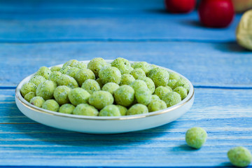 Wasabi peanut snack in a plate blue woody surface Chinese Japanese snack
