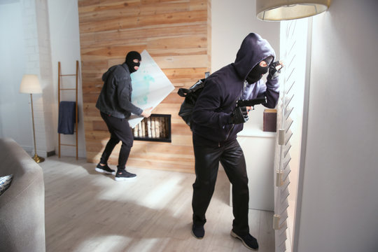 Dangerous masked criminals stealing picture from house