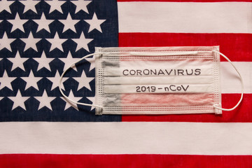 CORONAVIRUS. Protective medical mask on the background of the American flag . Concept of protection...