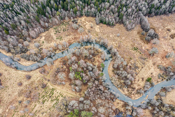 landscape at cloudy spring day with forest and winding river. aerial view from flying drone