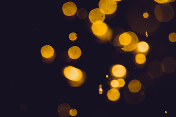 Dark Abstract Gold bokeh sparkle on black background