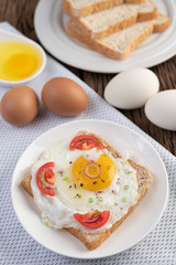 Fototapeta premium Bread placed with a fried egg with tomatoes, tapioca flour and sliced ​​spring onions.