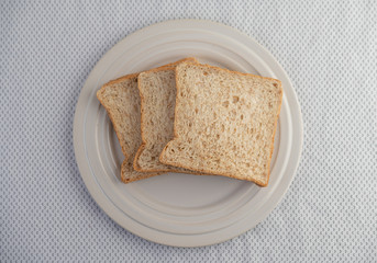 A slice of bread on a plate on a white background