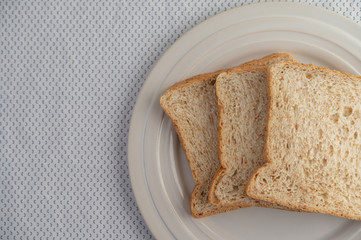 A slice of bread on a plate on a white background