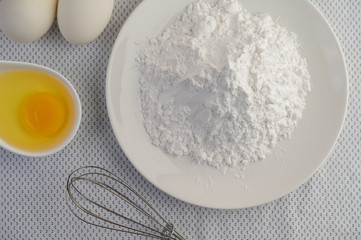 Eggs, tapioca flour and an egg beater, ingredients used in bakery