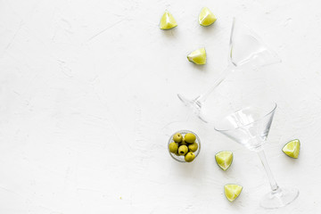Cocktail concept. Martini glasses near olives and lemon on white background copy space