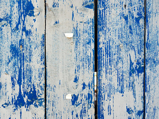 Shabby wooden planks with cracked blue colored old paint