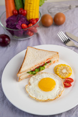 Fototapeta na wymiar American breakfast on a white background with fried egg, salad, pumpkin, cucumber, carrot, corn, cauliflower, tomato and sandwich