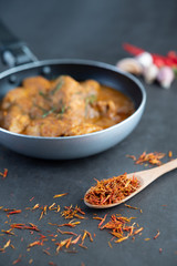 Massaman curry in a frying pan with spices on the cement floor
