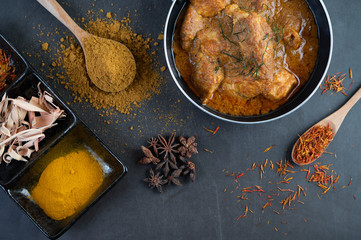 Massaman curry in a frying pan with spices on the cement floor