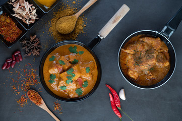 Massaman curry in a frying pan with spices on the cement floor