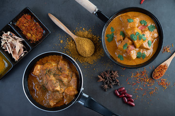 Massaman curry in a frying pan with spices on the cement floor