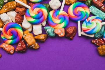 Lollipops and candy pebbles. sweets in the form of colored stones. colored background with colorful candies