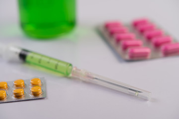 Medicine panels, syringes and beakers are placed on the floor.