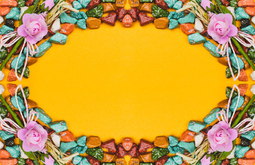 Candy pebbles on a yellow background. sweets in the form of colored stones. symmetrical frame made from colorful candies