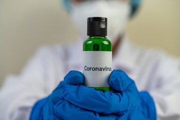 Scientists wearing masks and gloves, carrying vials with vaccines to protect Covid-19