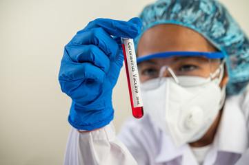 Scientists wear gloves and hold beakers.