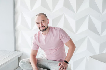 A young man with a beard smiles