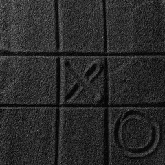 Playing on the black sand beach. Drawing with finger. Cross-zero. Tic-tac-toe game.
