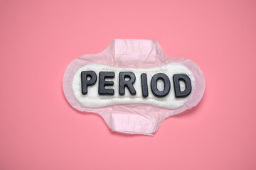 top view flat lay inscription period on cotton pad on a pastel pink background