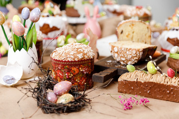 Easter cake orthodox sweet bread kulich and colorful chocolate eggs on festive table