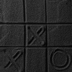 Playing on the black sand beach. Drawing with finger. Cross-zero. Tic-tac-toe game.