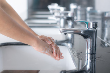 Washing hands with soap under the faucet with water. Protective coronavirus or covid-19 concept.