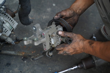 Dirty hands working on car's engine