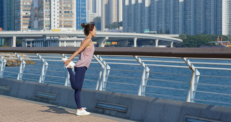 Woman stretch legs before running at outdoor