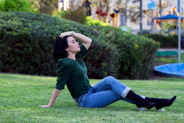 Fototapeta premium Beautiful girl enjoying nature outdoors in a park. The girl laughs and rejoices, a positive emotion. 