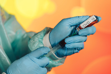 A blue-gloved medical worker draws an ampoule into a syringe. Medical vaccination against coronavirus flu concept. injection bottle for medical glass vials. COVID pandemic