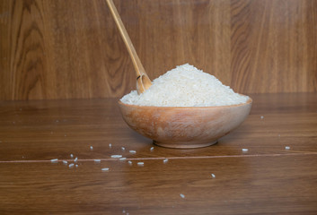 bowls with rice grains on wooden boards with wooden handmade spoon