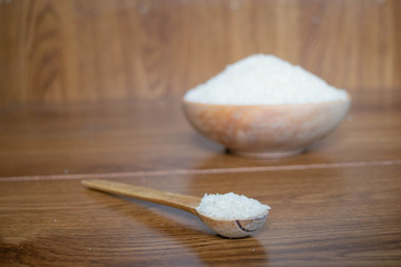 bowls with rice grains on wooden boards with wooden handmade spoon