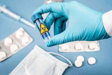 A doctor in a protective suit holds a medicine against coronavirus. COVID-19 concept