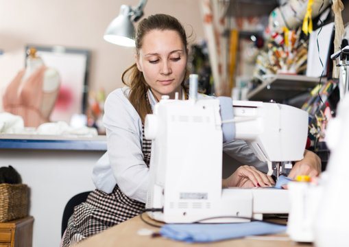 Portrait of woman designer who is working with sewing machine