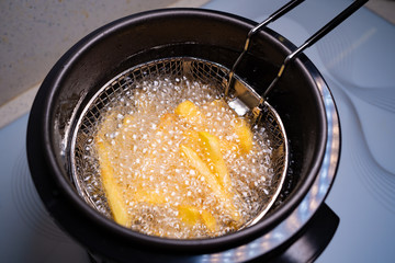 French fries. oil boiling in a deep fryer at home.