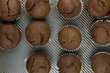 Top view simple chia seed chocolate muffins on a rustic baking sheet.