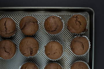 Top view simple chia seed chocolate muffins on a rustic baking sheet.