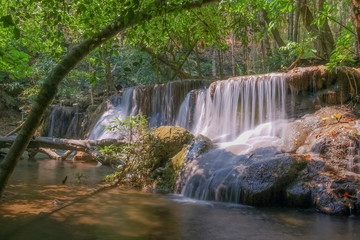 Fototapeta na wymiar Beautiful silky water flowing on rock cliff around with green forest background, Huay Mae Khamin floor 7th. (Rom Klaw), Kanchanaburi, west of Thailand. 