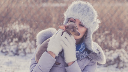 Woman playing with dog during winter