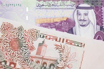 A beige, two hundred Algerian dinar bill with a colorful five Saudi riyal bank note close up in macro