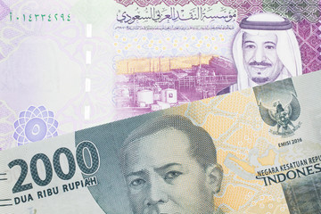 A gray two thousand Indonesian rupiah bank note with a five Saudi riyal note 